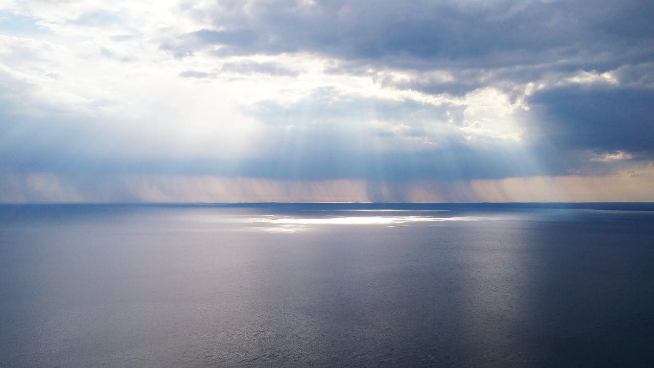 The Art of Drawing Readers In: Your attractive post title goes here Captivating ocean view with sunrays breaking through clouds, creating a serene and calming effect.